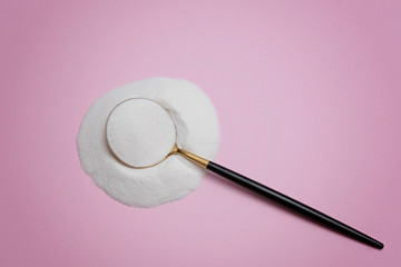collagen protein powder on a modern spoon on pink background