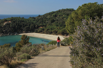 Young woman watching Fetovaia beach in wintertime, Elba island, Tuscany, Italy