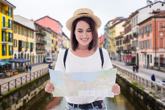 portrait of young beautiful woman tourist walking with map in italian town