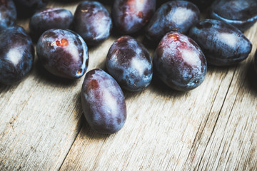 Fresh ripe plums on the rustic background. Selective focus. Shallow depth of field.