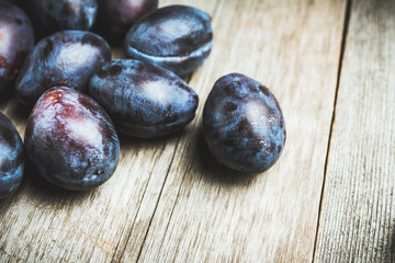 Fresh ripe plums on the rustic background. Selective focus. Shallow depth of field.