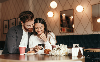 Young couple using smartphone during date