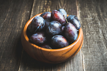 Fresh ripe plums on the rustic background. Selective focus. Shallow depth of field.
