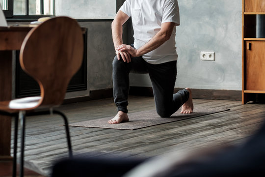 Senior Man Standing In Warrior Yoga Pose Variation Practicing In Living Room Alone. No Face View.