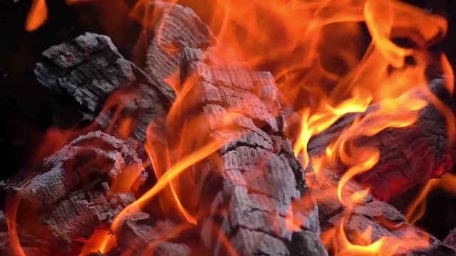 Slow motion of a fire flames and big live coals with ash and cinder in grill barbecue 
