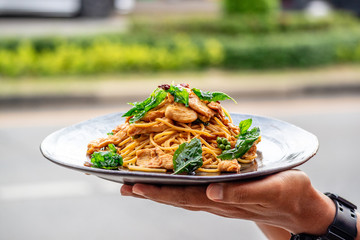 Stir Fry spaghetti with chicken and hearbs in black bowl
