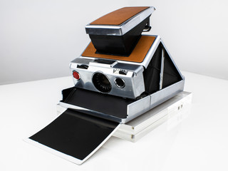 a vintage instant photo camera from the 70s silver with brown leather analog film professional land manual focus slr brown case iconic design nostalgic classic professional photographer travel product