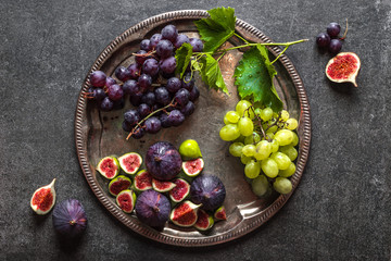 Fresh fruits on plate. Assorted grape and purple figs. Healthy food, vegan diet concept.
