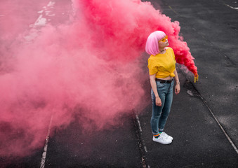 Stylish teenager standing near smoke bomb in city