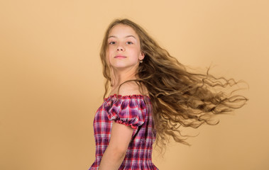 Hair like fire. hair health and care. hairdresser salon. beauty. kid fashion. long blond curly hair. beautiful little girl fashion model. small kid in dress. happy small girl with long healthy hair