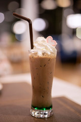 Cold cocoa in a tall glass with whipped cream