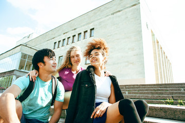 cute group of teenages at the building of university with books huggings, diversity nations students lifestyle