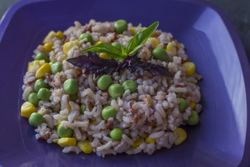 Plate with tasty brown rice and vegetables on a dark background. The concept of vegetarian food. Organic foods and fresh vegetables. Asian cuisine.