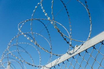fence with barbed wire, barbed wire against the blue sky