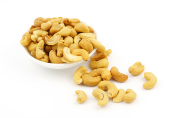 Roasted cashew nuts with salt in dish isolate on white background