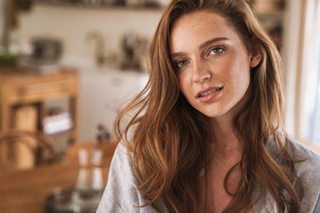 Optimistic happy pleased redhead woman indoors at home.