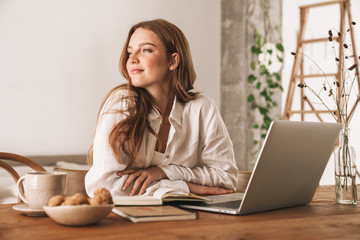 Business woman sit indoors in office using laptop computer.