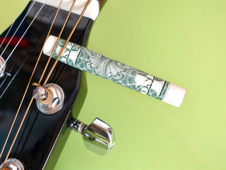 guitar headstock with tuning pegs  and dollar . color background . closeup