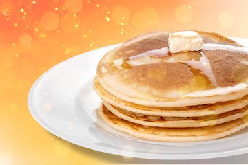Stack of tasty pancakes with butter on a white plate