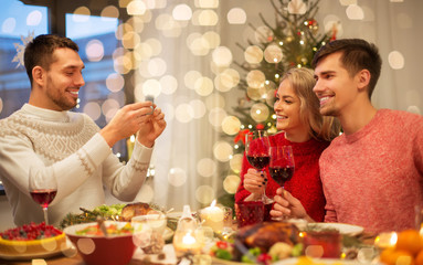 holidays and celebration concept - happy friends photographing at christmas dinner