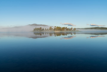 A small island in a lake on a tranquil, foggy morning. Ottsjon, Sweden.