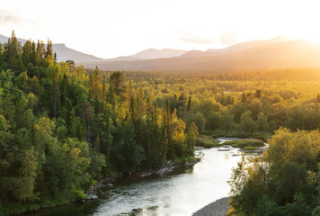 The sun setting over a river in a   mountain wilderness.  Jamtland, Sweden. © sanderstock