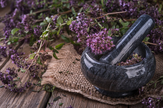 marble mortar with fresh green thyme on the black background
