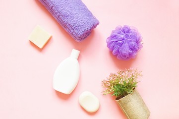 Fototapeta na wymiar Natural soap, organic shampoo, purple sponge and towel on a pink background. Flat lay toiletries kit, beauty photo