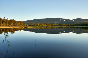 Mountains reflecting to still lake