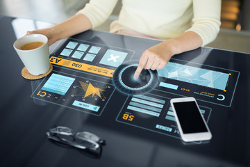 technology and people concept - close up of woman using interactive panel with virtual data and drinking coffee