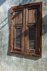 Wooden window isolated on  cement background. Window Close with the Cement wall have white color or color cement or plaster bare. The wood window on cement wall .