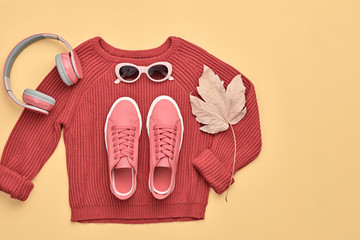 Hipster DJ trendy colorful autumn Outfit. Fall fashion minimal Flat lay. Pink jumper, Stylish sneakers, headphones. Creative Woman Clothes Accessories set, fall Girl fashionable autumnal orange color