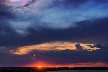 Fototapeta na wymiar low dark dramatic clouds over red sunset
