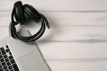 White wooden working desk with laptop and headphones. Background texture, copy space on the right side. Topview.
