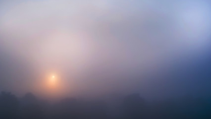 Colored sunrise in forested mountain slope with fog ,View from the mountain in the morning, Surat Thani, Thailand.
