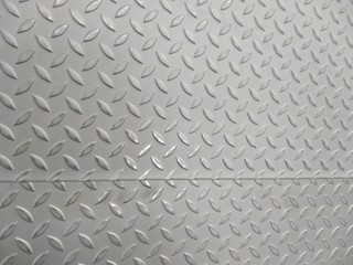 Laser cutting of stainless steel sheet, perforated steel for background.