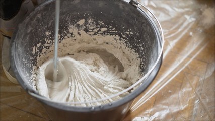 Stir the building mix in a bucket. Stirs the solution in a bucket