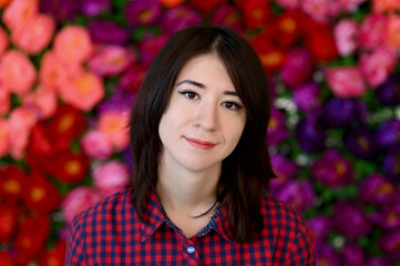 Close-up portrait of a pretty asian brunette girl with black hair on a colorful background. It stands right in front of the camera exactly.