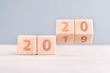 Abstract 2020 & 2019 New year countdown design concept - wood blocks cubes on wooden table and low...