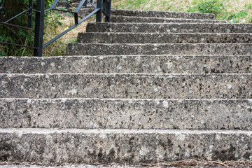 stone staircase going up with metal railing to one side