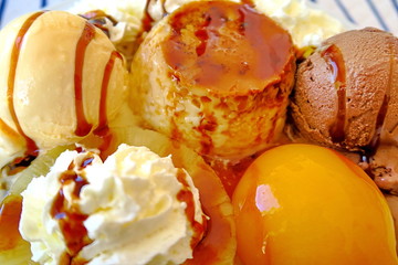 Dessert complet : glace vanille, glace chocolat, flan, crème chantilly; pêche au sirop; caramel.