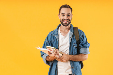 Image of content student guy smiling while holding exercise books - obrazy, fototapety, plakaty