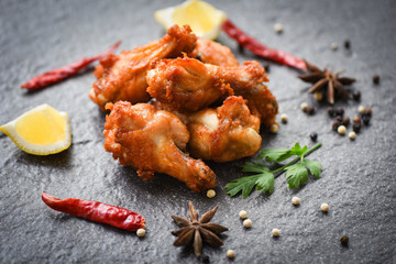 Fried chicken wings on black plate with lemon chilli herbs and spices - Baked chicken wings BBQ