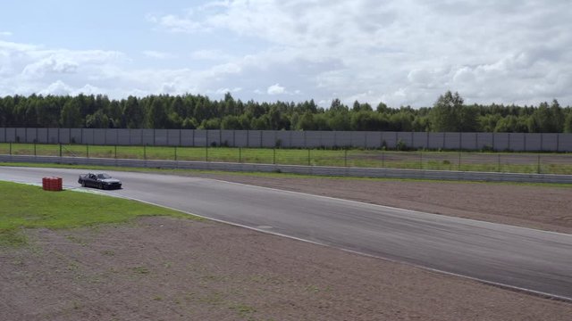 Racing car driving on speed rack. Aerial side view japanese car riding on racing track. Drone view driver training on racing car at ring