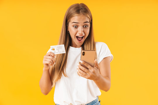 Image of excited woman smiling while holding smartphone and credit card