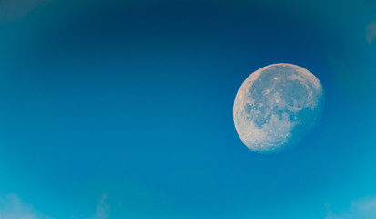 Fototapeta na wymiar Zachodzący księżyc widoczny na niebie o poranku