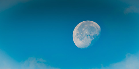 Obraz na płótnie Canvas Zachodzący księżyc widoczny na niebie o poranku