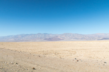 Fototapeta na wymiar View of a vast Death Valley landscape, empty roads , rock formations and the badwater basin salt deposits.