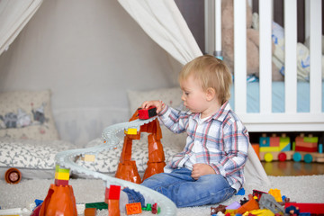 Child toddler playing with construction toys at home