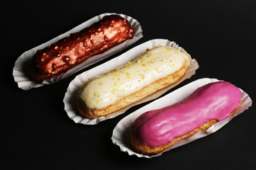 Eclair french cake delicious dessert on black background close up food photo